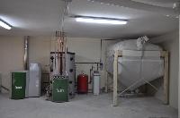 imagen de caldera de pellet, deposito de inercia y silo de pellets en sala de máquinas